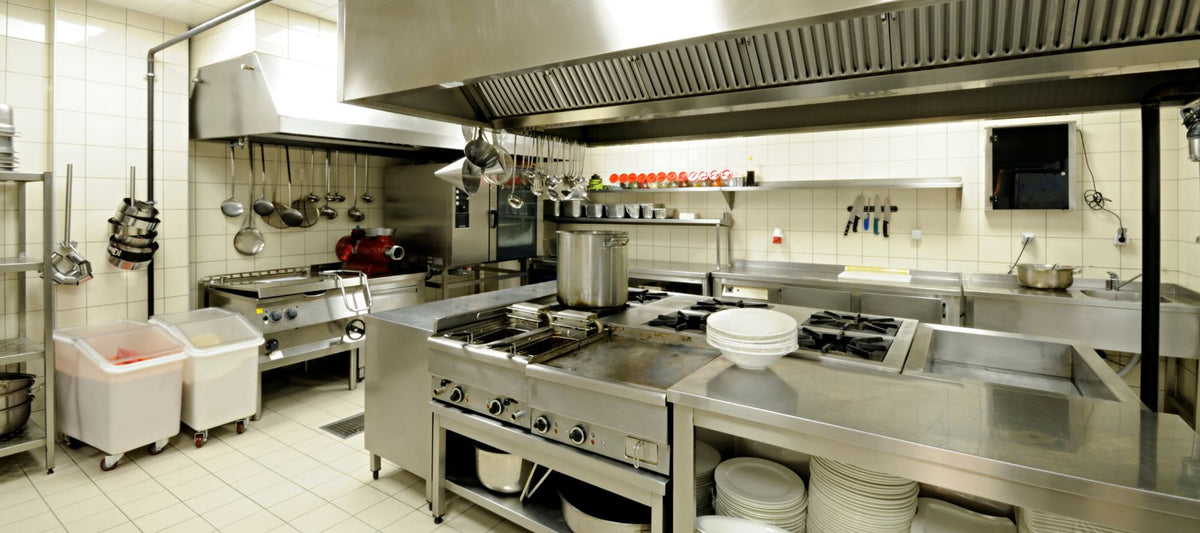 Saubere Gastroküche aus Edelstahl mit Herd, Fritteuse und Kombi-Steamer